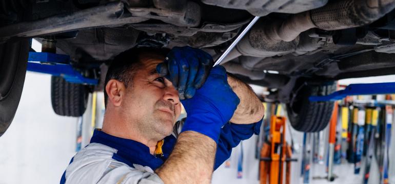 Mechanik v autoservise uvoľňuje skrutku olejovej vane